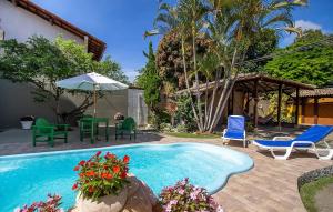 uma piscina com cadeiras e uma mesa e cadeiras em Villa Sunset em Arraial d'Ajuda