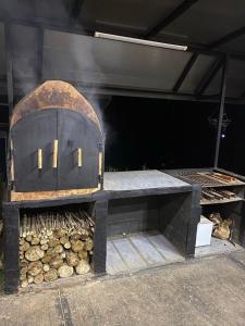 a charcoal grill with a pile of fire wood at Eco Lung Hotel in Montezuma
