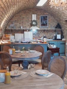 ein Restaurant mit Tischen und Stühlen und eine Küche in der Unterkunft Maison Bagatell Badacsony in Badacsonytomaj