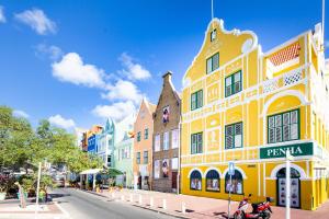 a yellow building on the side of a street at World Heritage Apartments in Willemstad