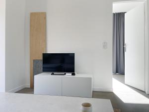 a living room with a tv on a white cabinet at Bieleniówka in Nakielno