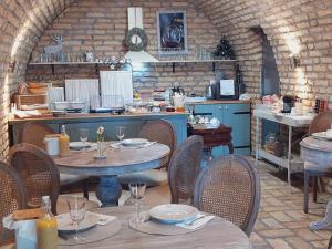 a restaurant with tables and chairs and a kitchen at Maison Bagatell Badacsony in Badacsonytomaj