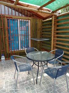 une table et des chaises en verre sur la terrasse dans l'établissement Las 3 Golondrinas, à El Quisco