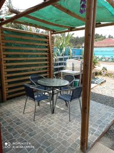 d'une terrasse avec une table et des chaises sous une pergola. dans l'établissement Las 3 Golondrinas, à El Quisco