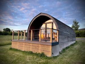 a small building with a large window in a field at Hood Lane Farm - The Pod - Luxury Glamping Holiday Lodge in Arley