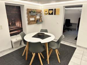a dining room with a white table and chairs at Modernes Apartment mit Terrasse und Highspeed Internet zwischen Aalen und Schwäbisch Gmünd in Göggingen