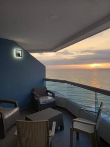 uma varanda de um navio de cruzeiro com cadeiras e um pôr-do-sol em Edif. Deymar - Departamento frente al mar 9no piso em Tonsupa