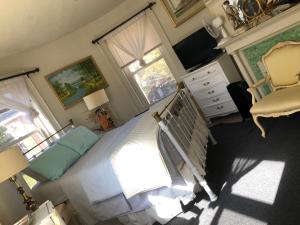 a bedroom with a bed and a tv and window at Highland Park Pittsburgh in Pittsburgh