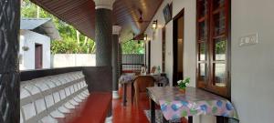 a patio with a table and chairs in a building at Marari Casa Almare in Mararikulam