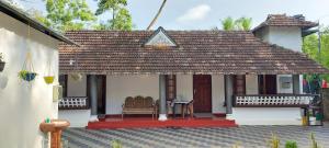 a small house with a roof with a table and chairs at Marari Casa Almare in Mararikulam