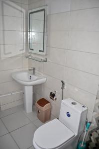 a white bathroom with a toilet and a sink at Appart luxueux moderne 2 lits 2 douches Makepe in Deido