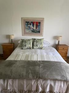 1 dormitorio con 1 cama blanca y 2 mesitas de noche en HEELTEVREDE Self-Catering farmhouse, en Bloemfontein