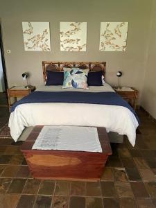 a bedroom with a large bed with a wooden headboard at HEELTEVREDE Self-Catering farmhouse in Bloemfontein