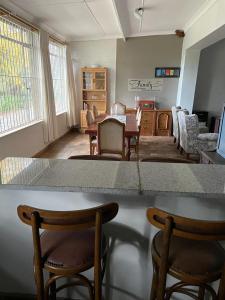 a living room with a table and chairs and a living room at HEELTEVREDE Self-Catering farmhouse in Bloemfontein