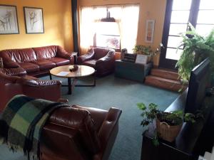sala de estar con sofás de cuero y mesa en Zoete Inval, en Hermanus