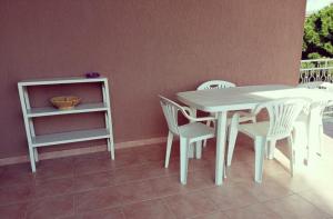 a white table and chairs and a table and a shelf at Il Quadrifoglio di Triveri in Bovalino Marina