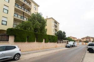 una calle con coches estacionados en el lateral de un edificio en R&B Vistahermosa Views en El Puerto de Santa María