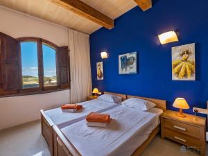 a blue bedroom with a bed with two pillows on it at The Arches Holiday Home in Kerċem