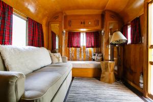 een woonkamer met een bank en een bed in een trein bij The Vintages Trailer Resort in Dayton