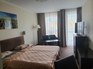 a hotel room with a bed and a flat screen tv at Apartament 307 w 4-gwiazdkowym Hotelu DIVA SPA w Kołobrzegu in Kołobrzeg