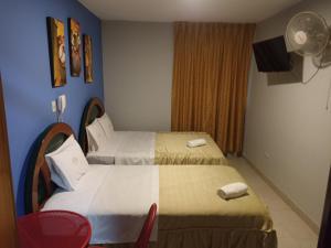 um quarto de hotel com duas camas e uma janela em HOTEL ALFONSO UGARTE em Chiclayo