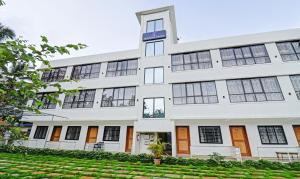 an exterior view of a white building with a yard at Itsy By Treebo - Morjim Pride in Morjim