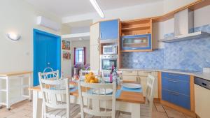 cocina y comedor con mesa y sillas en Refurbished beachfront house, Pool, AC, WiFi, Albufeira, sea view, en Albufeira