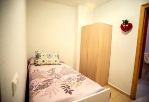 Habitación pequeña con cama con almohada. en APARTAMENTOS SAN ANTON, en Villarrobledo