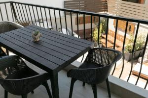 a wooden table with chairs and a plant on a balcony at ridos house in Neos Marmaras