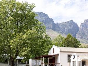 a white building with mountains in the background at Jonkershoek Valley Cottage in Stellenbosch