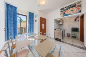 a dining room with a glass table and a kitchen at Nuova Aurora in Marghera