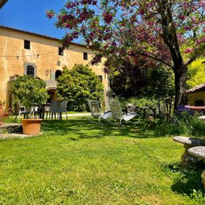 um grupo de cadeiras sentadas na relva num quintal em Podere il Casone em Serravalle Pistoiese