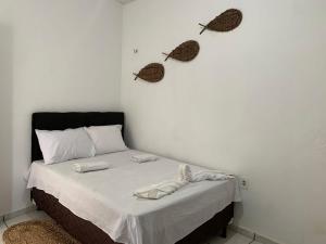 a bedroom with a bed with two butterflies on the wall at Pousada Meu Xodó in Barreirinhas