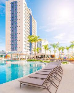 uma piscina do hotel com espreguiçadeiras e um edifício em Salinas Exclusive Resort em Salinópolis