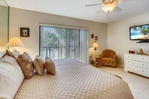 a bedroom with a large bed and a window at Land's End 10-201 Beach Front - Premier in St Pete Beach