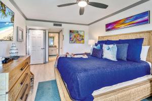 um quarto com uma cama azul e uma ventoinha de tecto em Land's End 10-202 Beach Front - Premier em St. Pete Beach