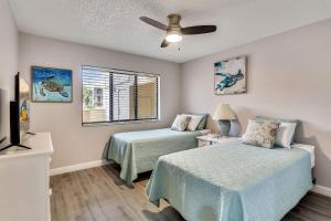 1 dormitorio con 2 camas y ventilador de techo en Land's End 4-202 Bay Front - Premier, en St Pete Beach
