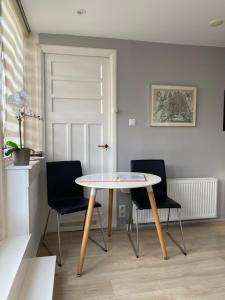 a dining room with a table and two chairs at Rooftop Terrace Apartment in Amsterdam