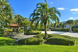 a park with a palm tree and a gazebo at Land's End 4-202 Bay Front - Premier in St. Pete Beach