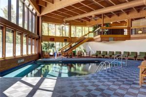a swimming pool in a large building with windows at Slope Side Ski In Ski Out at Beaver Run Resort in Breckenridge