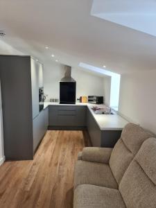 a living room with a couch and a kitchen at Town Centre Apartment in Leek