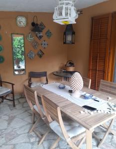 a dining room with a wooden table and chairs at Scopello Dream House, villaggio CALA AZZURRA in Scopello