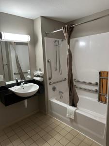 uma casa de banho com um lavatório, uma banheira e um WC. em Motel 6-Greensboro, NC - Airport em Greensboro