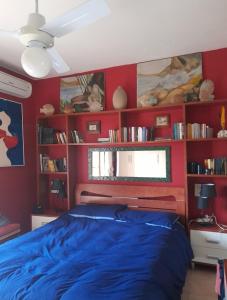 スコペッロにあるScopello Dream Houseのベッドルーム1室(青いベッド1台、赤い壁付)