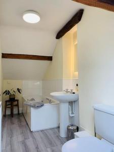 a white bathroom with a sink and a tub at Orchard Cottage in Corwen