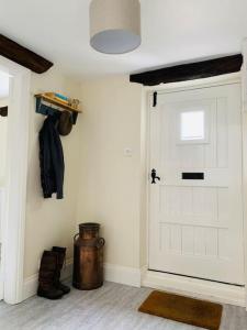 una habitación con una puerta de garaje blanca y una olla en Orchard Cottage, en Corwen