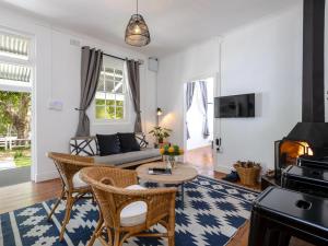 ein Wohnzimmer mit einem Sofa und einem Tisch in der Unterkunft Jonkershoek Valley Cottage in Stellenbosch
