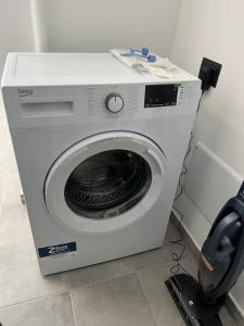 eine weiße Waschmaschine mit einem Telefon daneben in der Unterkunft H92 bari in Bari
