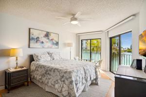 a bedroom with a bed and a table with a ceiling fan at Land's End 5-204 Gulf-Bay Front - Premier in St. Pete Beach +37 photos