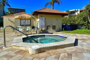 a small swimming pool in a patio with a house at Land's End 6-205 Beach Front - Premier in St. Pete Beach